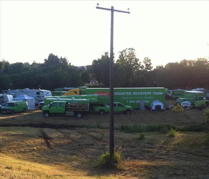SERVPRO trucks and vehicles parked outside of a large loss.