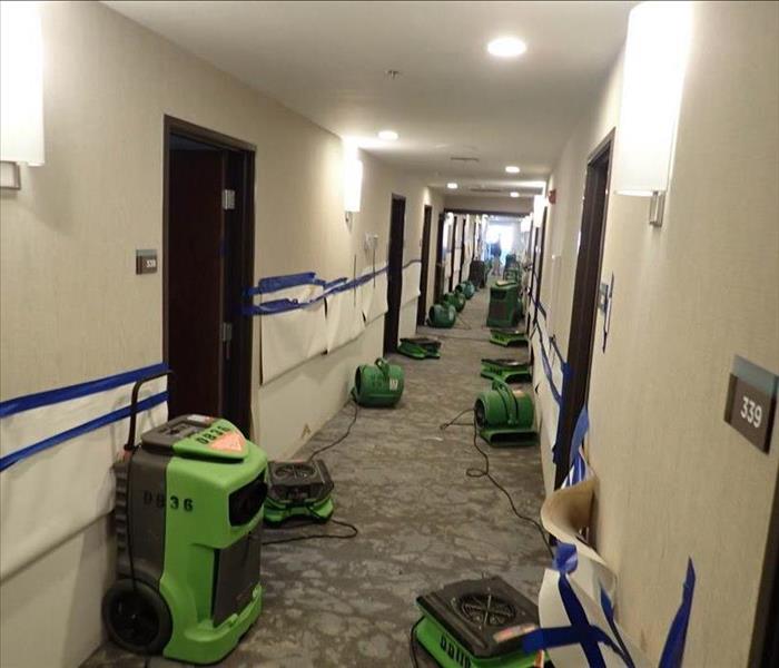 Hallway full of water drying equipment.