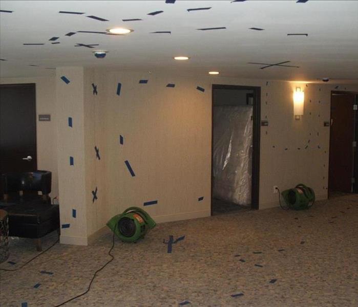 Air movers on floor & tape markings on wall.